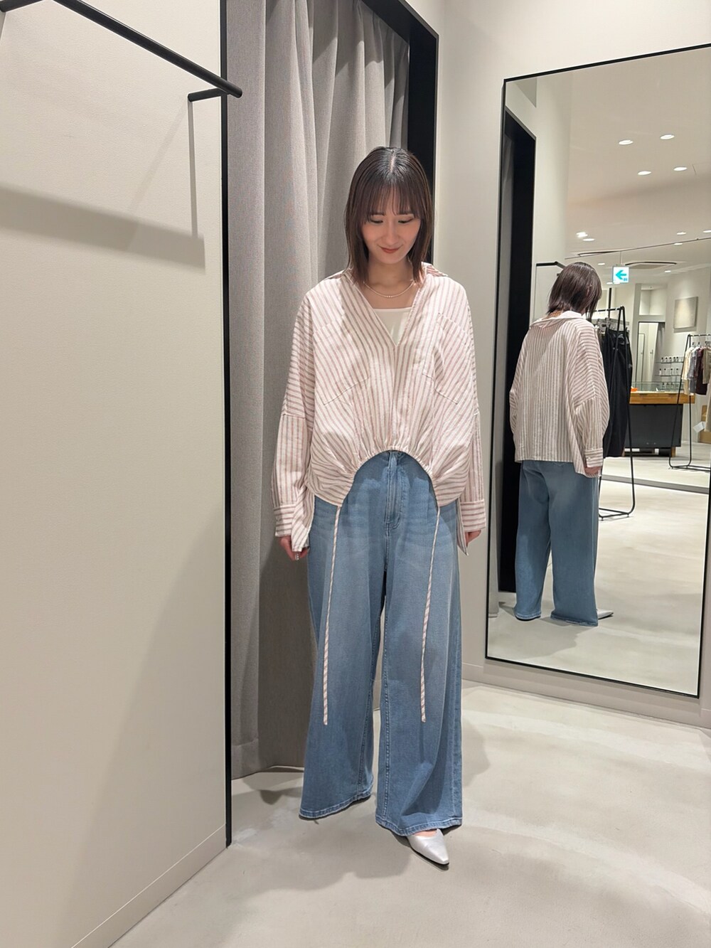 レッド系のシャツ/ブラウス、ホワイト系のタンクトップ、ブルー系のデニムパンツを着用したレディースの春コーディネートの3枚目の写真