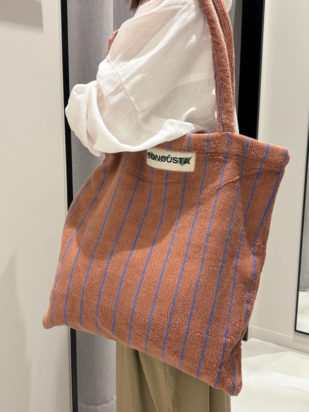 ベージュ系のその他パンツ、ベージュ系のサンダル、イエロー系のトートバッグを着用したレディースの春コーディネートの5枚目の写真