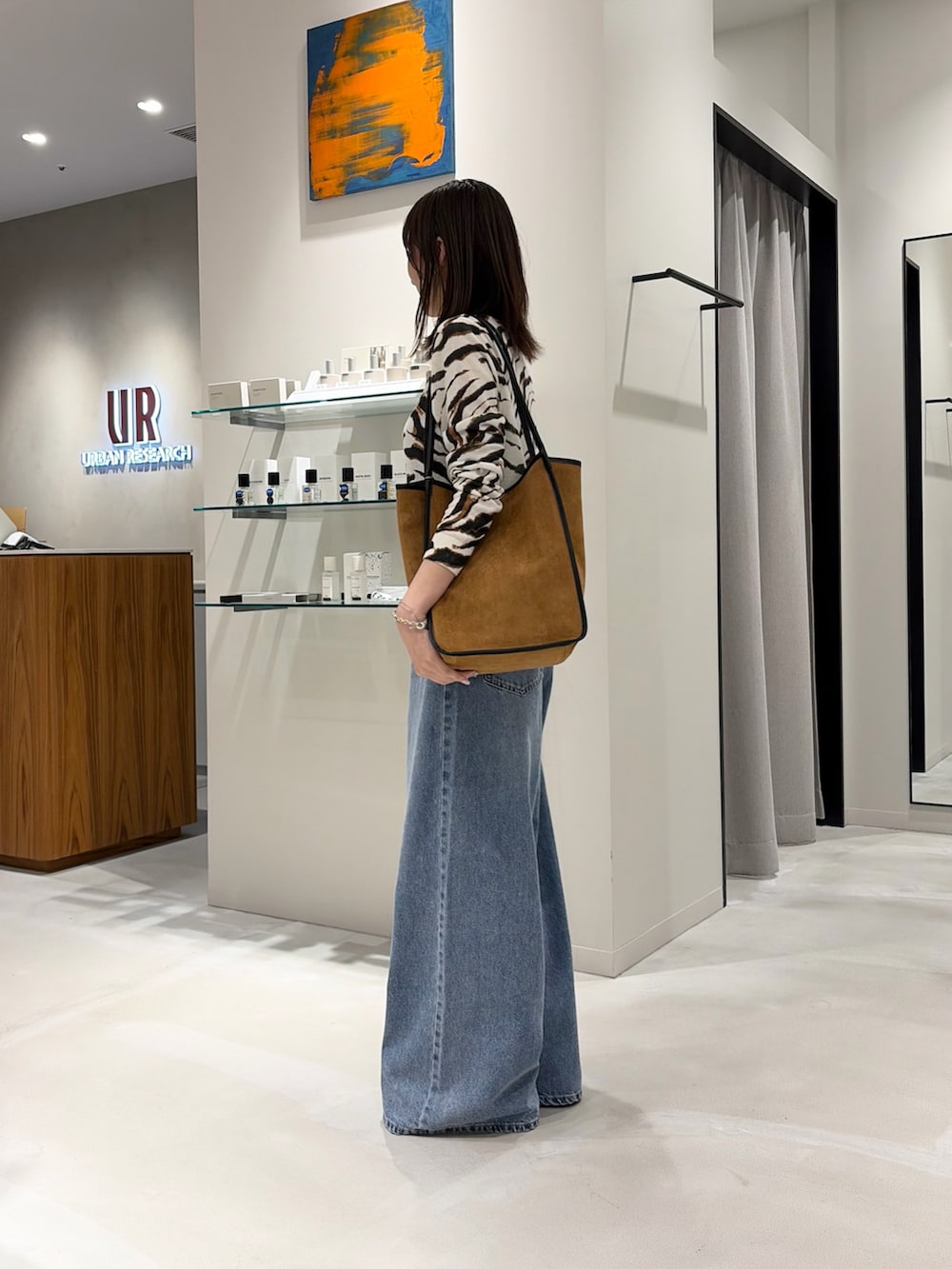 その他のカーディガン/ボレロ、ブルー系のデニムパンツ、ブラウン系のトートバッグを着用したレディースの秋コーディネートの3枚目の写真