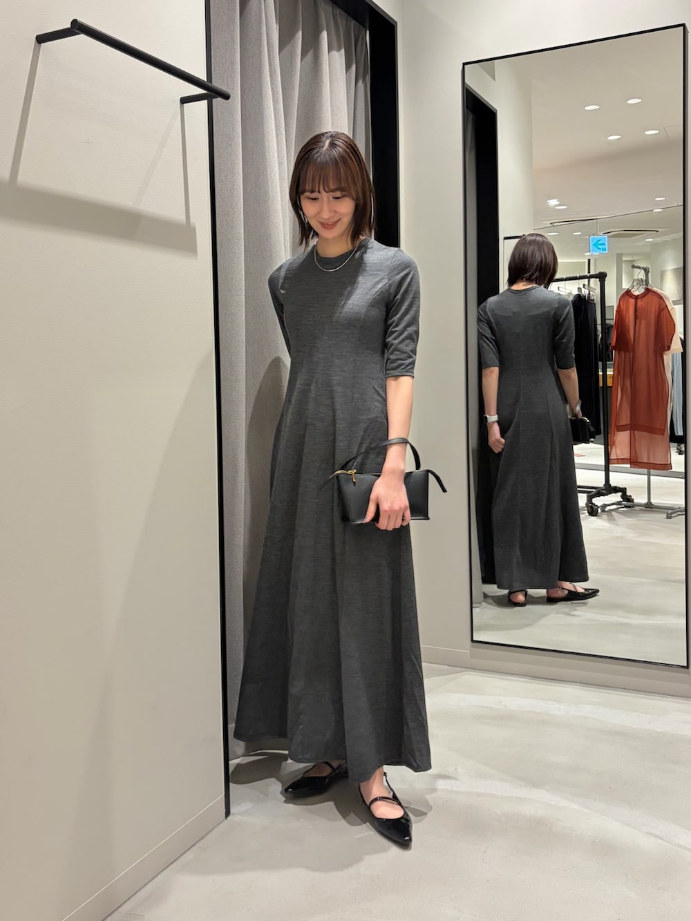 ブラック系のその他アウター、ブラック系のハンドバッグ、ブラック系のパンプスを着用したレディースの冬コーディネートの6枚目の写真