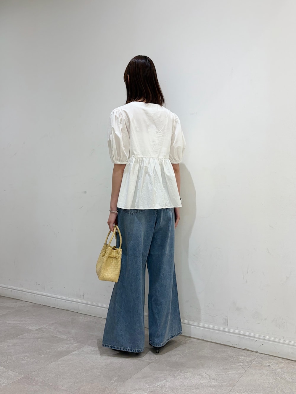ホワイト系のシャツ/ブラウス、ブルー系のデニムパンツ、ベージュ系のトートバッグを着用したレディースの夏コーディネートの3枚目の写真