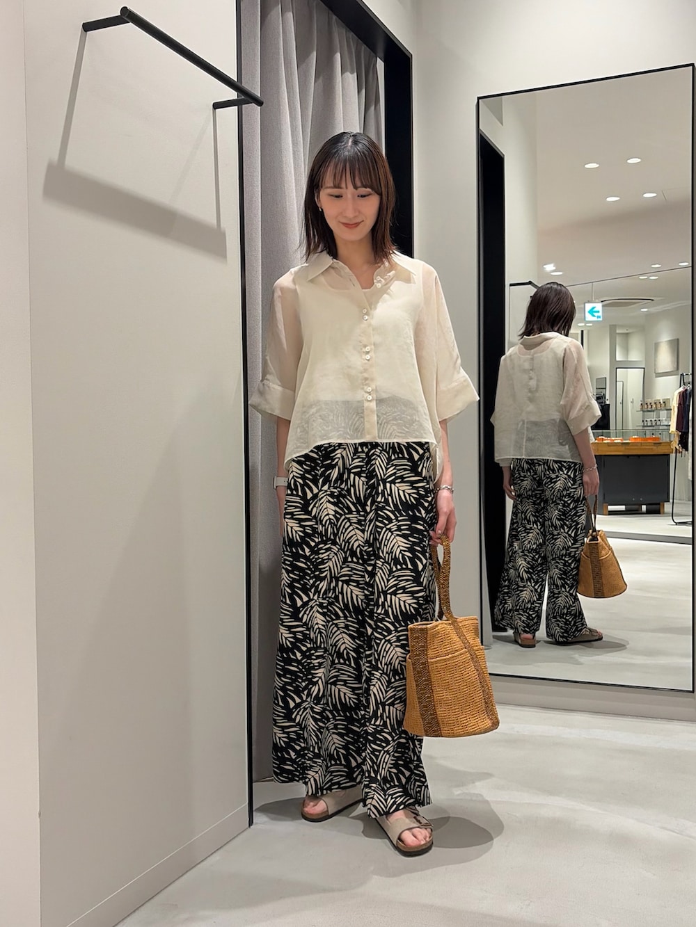 ブラック系のその他パンツ、ベージュ系のバッグ、ベージュ系のサンダルを着用したレディースの春コーディネートの2枚目の写真