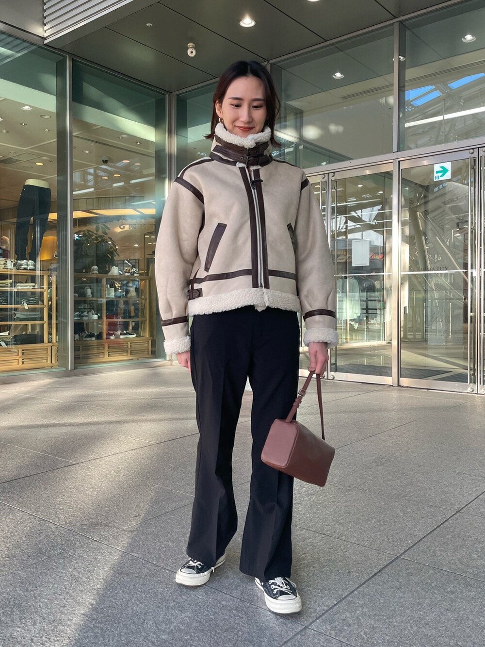 ベージュ系のブルゾン、ブラック系のその他パンツ、ブラウン系のボストンバッグを着用したレディースの冬コーディネートの3枚目の写真