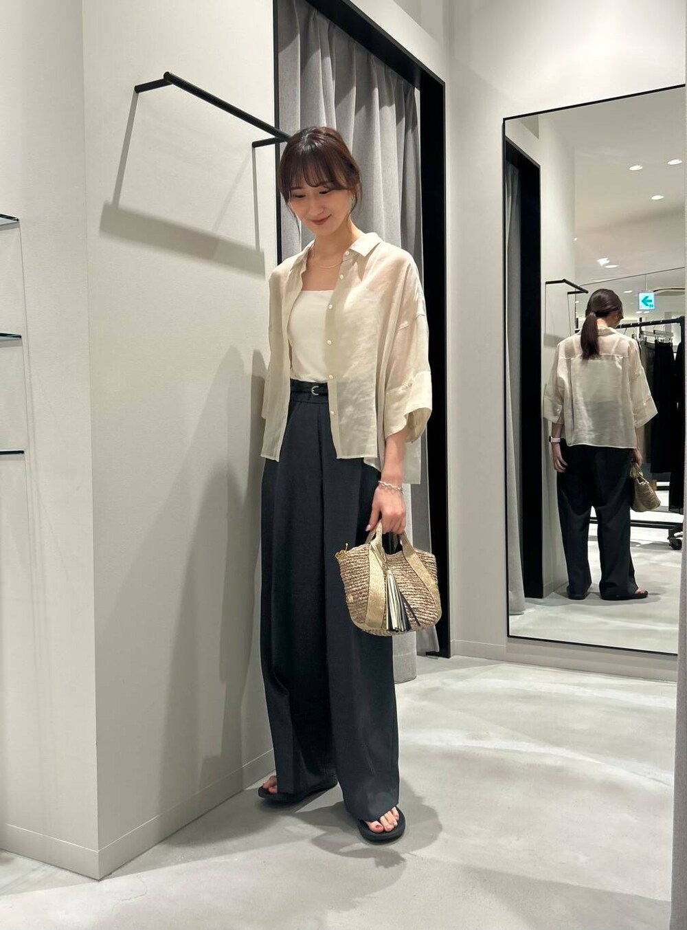 ゴールド系のかごバッグ、ブラック系のサンダル、グレー系のその他パンツを着用したレディースの夏コーディネートの2枚目の写真