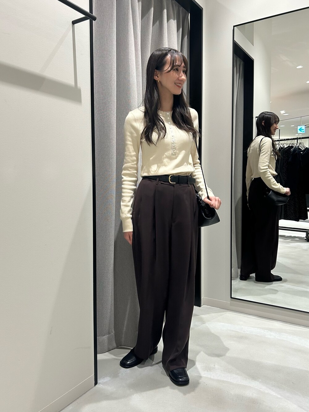 ホワイト系のTシャツ/カットソー、ブラウン系のその他パンツ、ブラック系のハンドバッグを着用したレディースの秋コーディネートの3枚目の写真