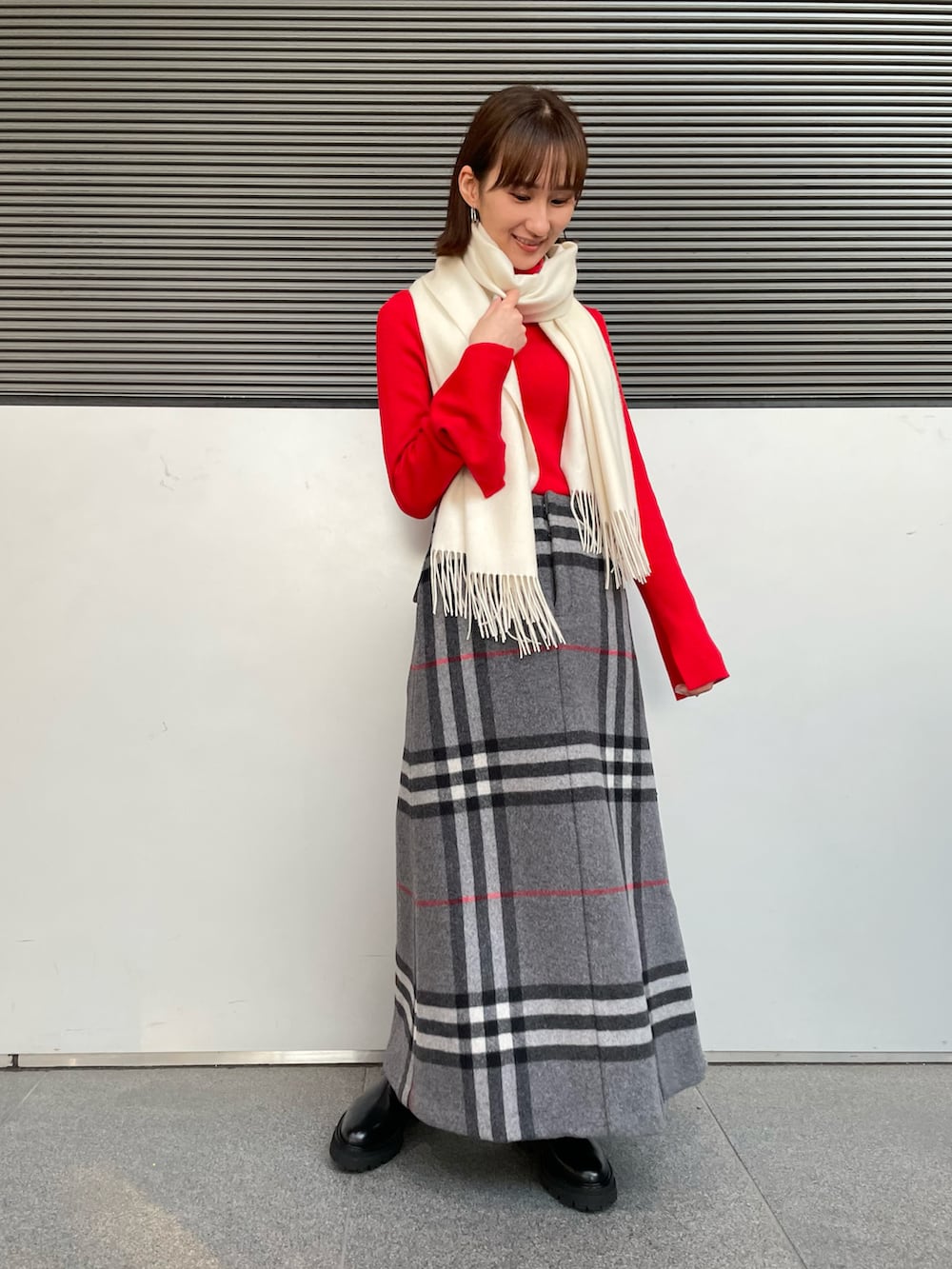 ベージュ系のダウンジャケット/コート、ブラック系のブーツ、ホワイト系のマフラーを着用したレディースの冬コーディネートの3枚目の写真