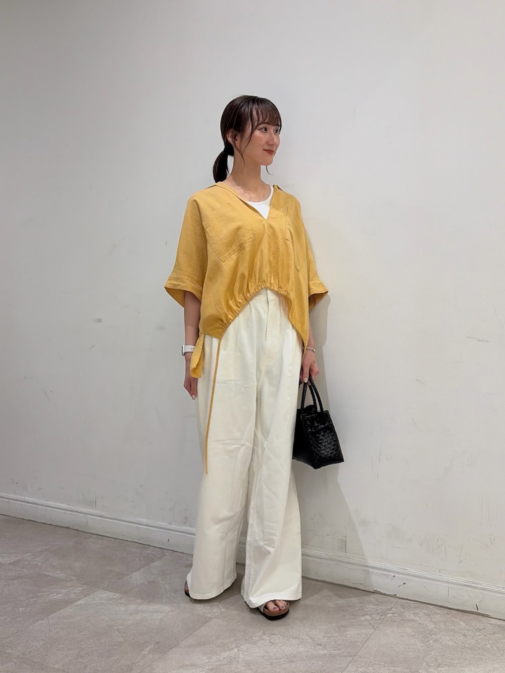 ホワイト系のタンクトップ、ホワイト系のデニムパンツ、ベージュ系のサンダルを着用したレディースの夏コーディネートの2枚目の写真