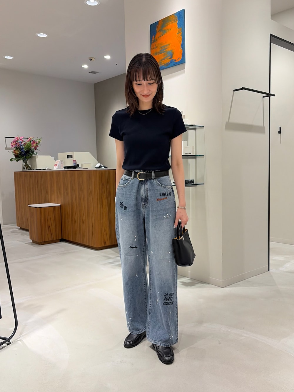 ブルー系のTシャツ/カットソー、ブラック系のローファー、ブルー系のデニムパンツを着用したレディースの夏コーディネートの2枚目の写真