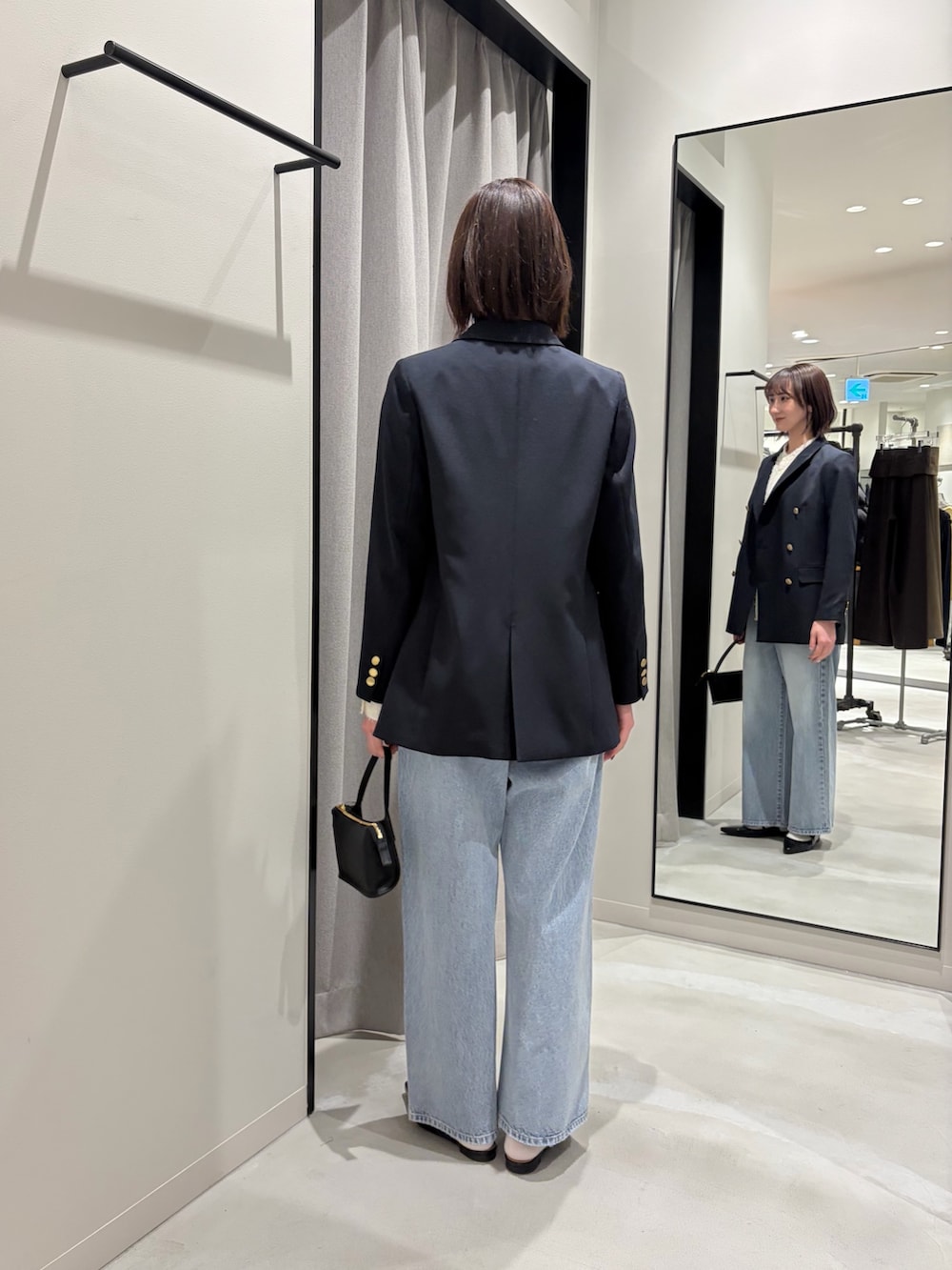 ブルー系のその他アウター、ホワイト系のシャツ/ブラウス、ブラック系のハンドバッグを着用したレディースの冬コーディネートの3枚目の写真