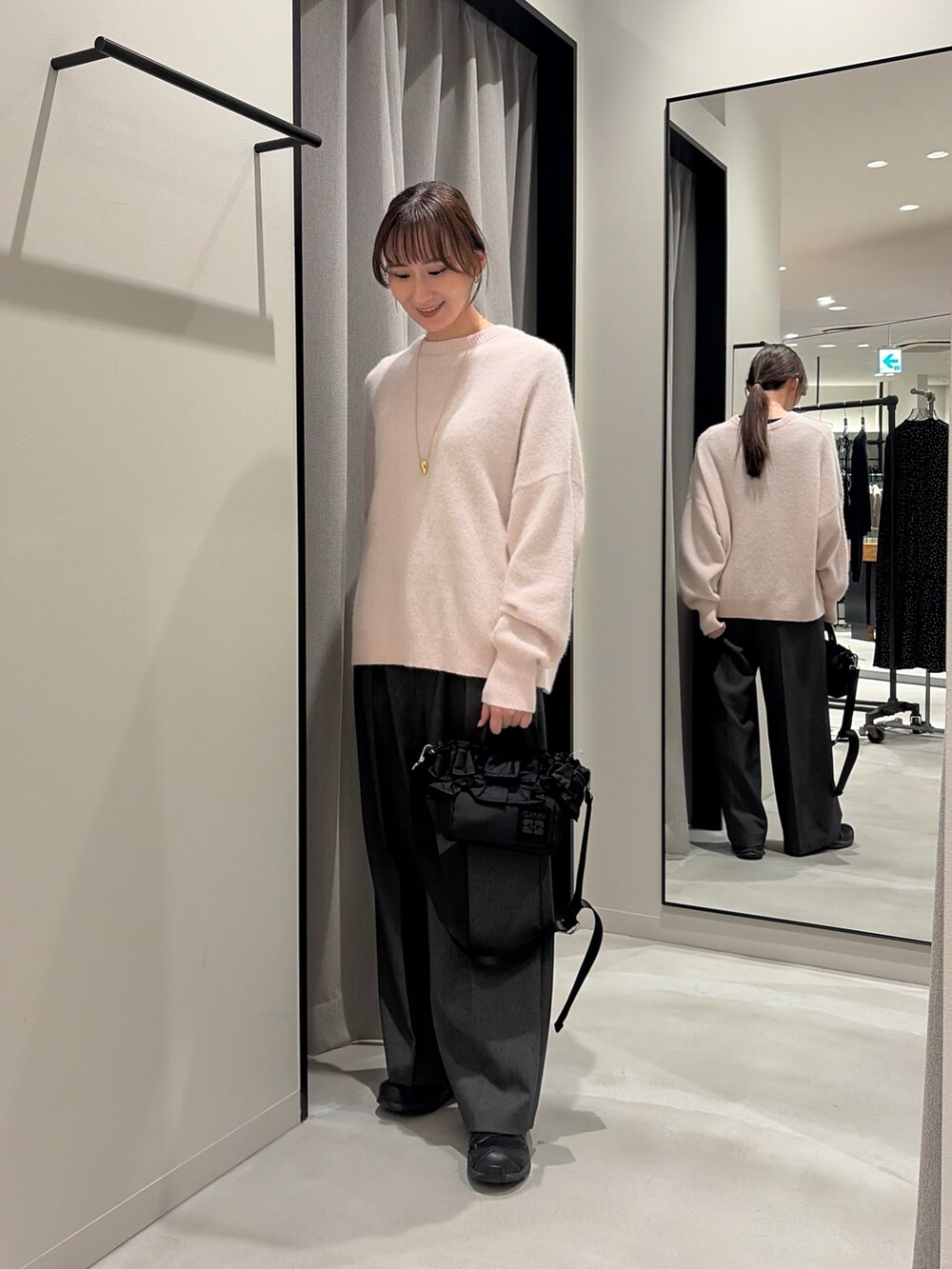 グレー系のその他パンツ、ブラック系のハンドバッグ、ピンク系のニット/セーターを着用したレディースの冬コーディネートの2枚目の写真