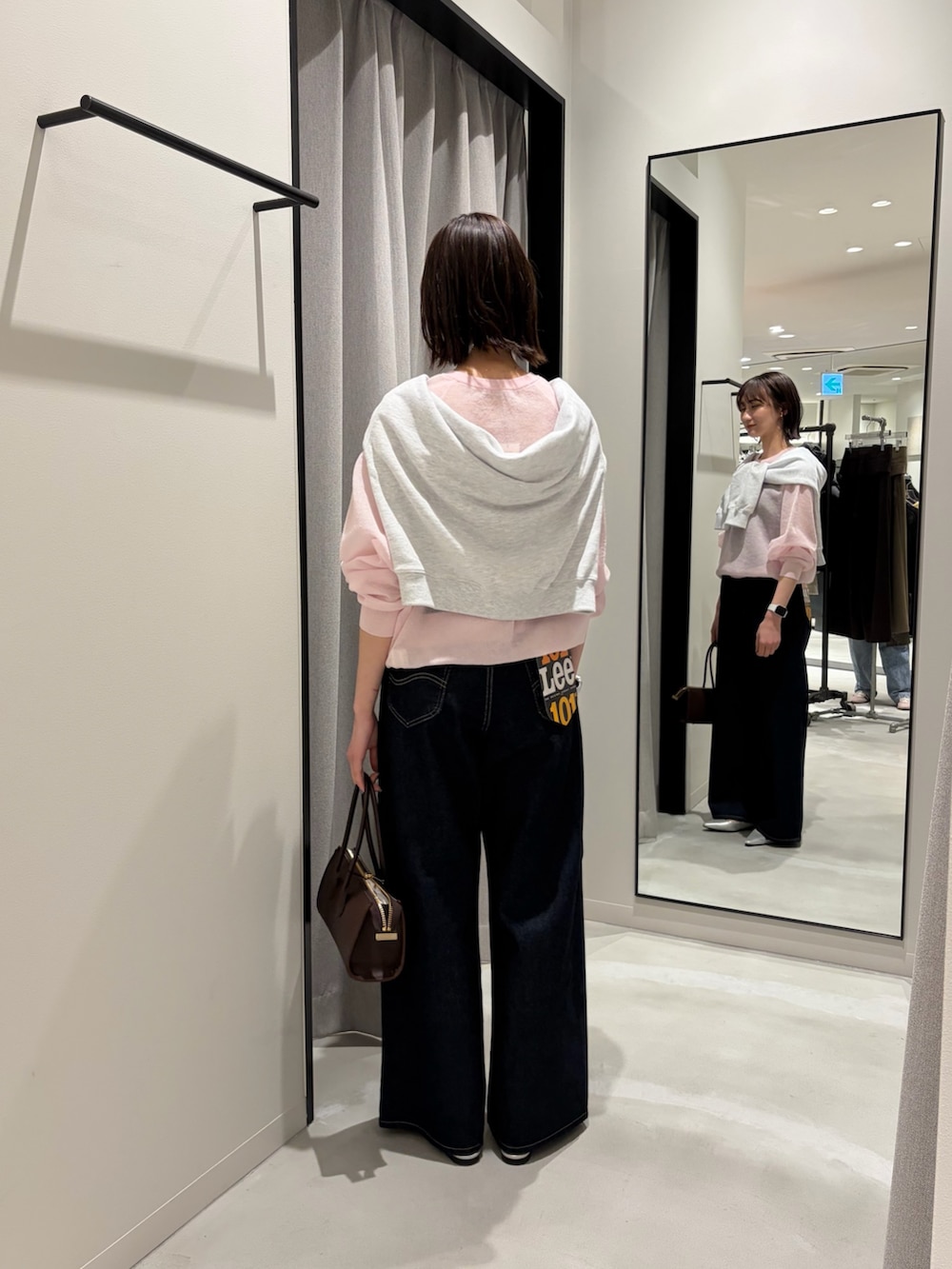 ピンク系のニット/セーター、グレー系のスウェット、ブルー系のデニムパンツを着用したレディースの冬コーディネートの3枚目の写真