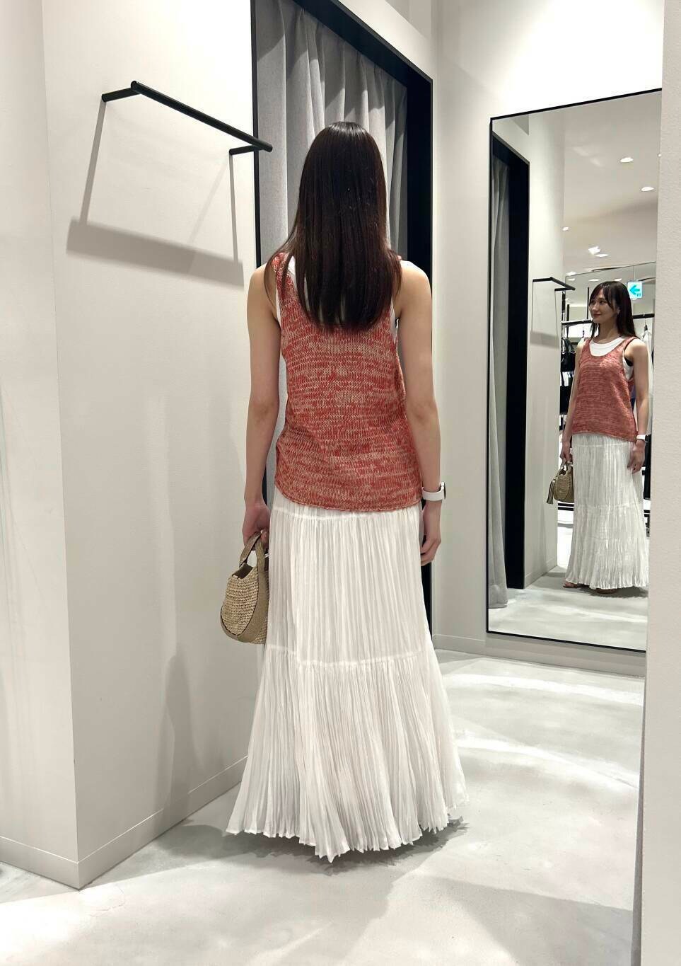 ベージュ系のかごバッグ、ホワイト系のスカート、ゴールド系のサンダルを着用したレディースの夏コーディネートの4枚目の写真