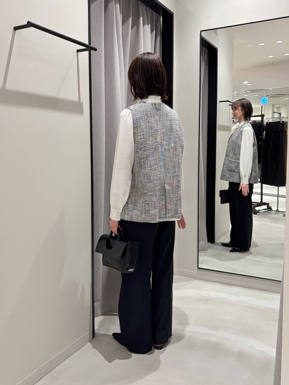 ブラック系のその他アウター、ホワイト系のシャツ/ブラウス、ブラック系のその他パンツを着用したレディースの冬コーディネートの3枚目の写真