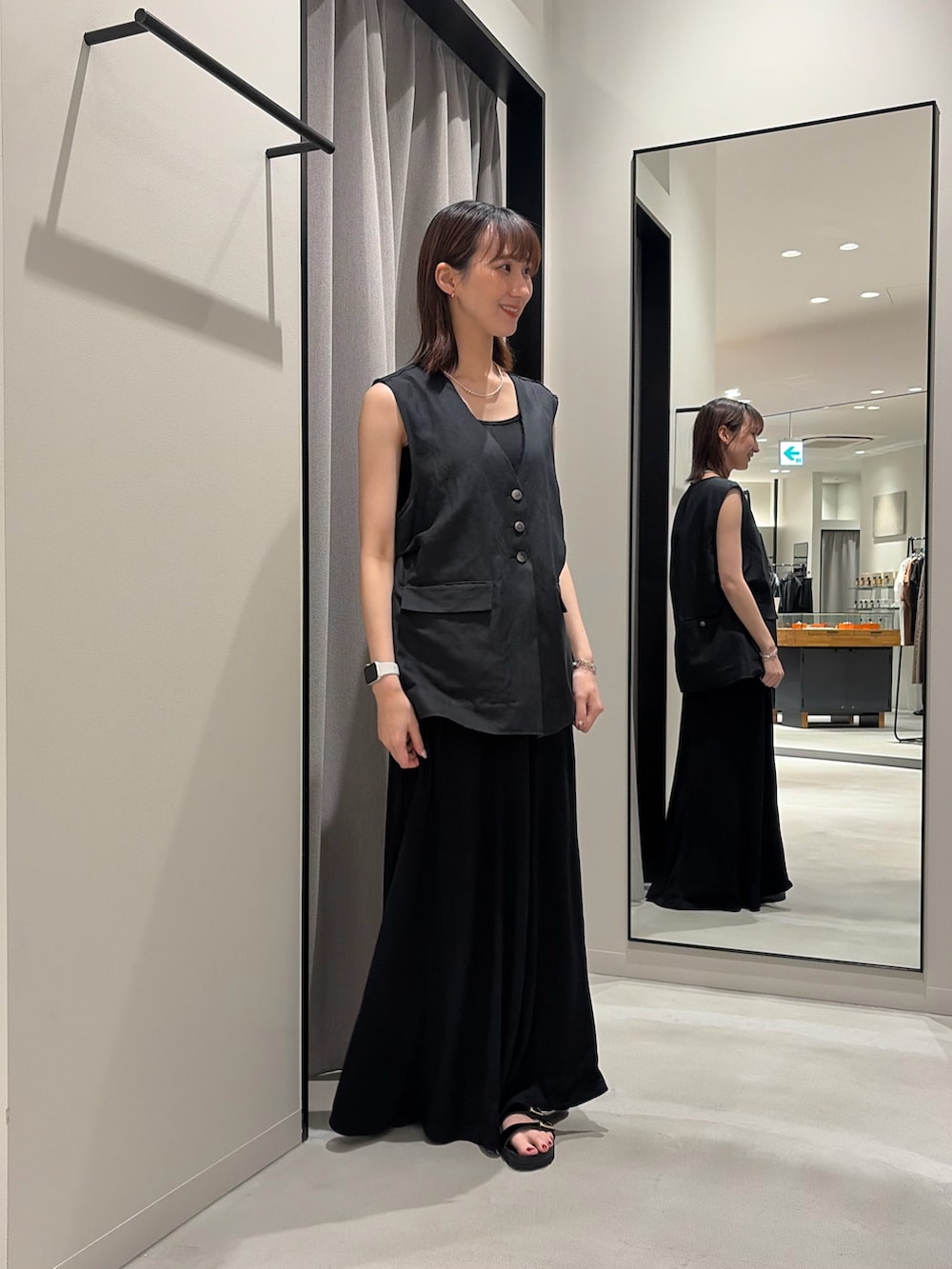 ブラック系のワンピース、ブラック系のダウンベスト、ブラック系のニット/セーターを着用したレディースの春コーディネートの3枚目の写真