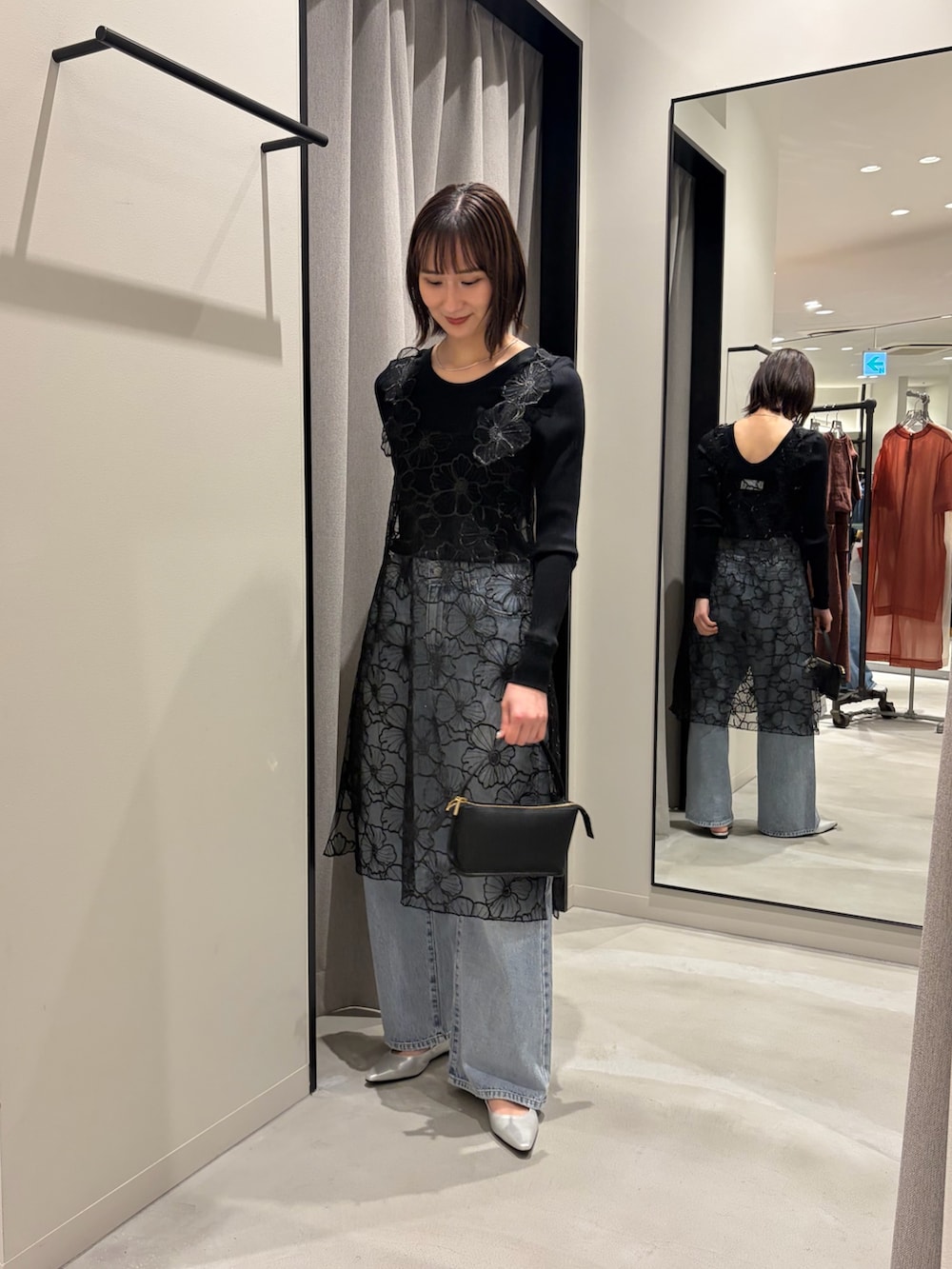 ブラック系のTシャツ/カットソー、ブルー系のデニムパンツ、シルバー系のパンプスを着用したレディースの冬コーディネートの5枚目の写真