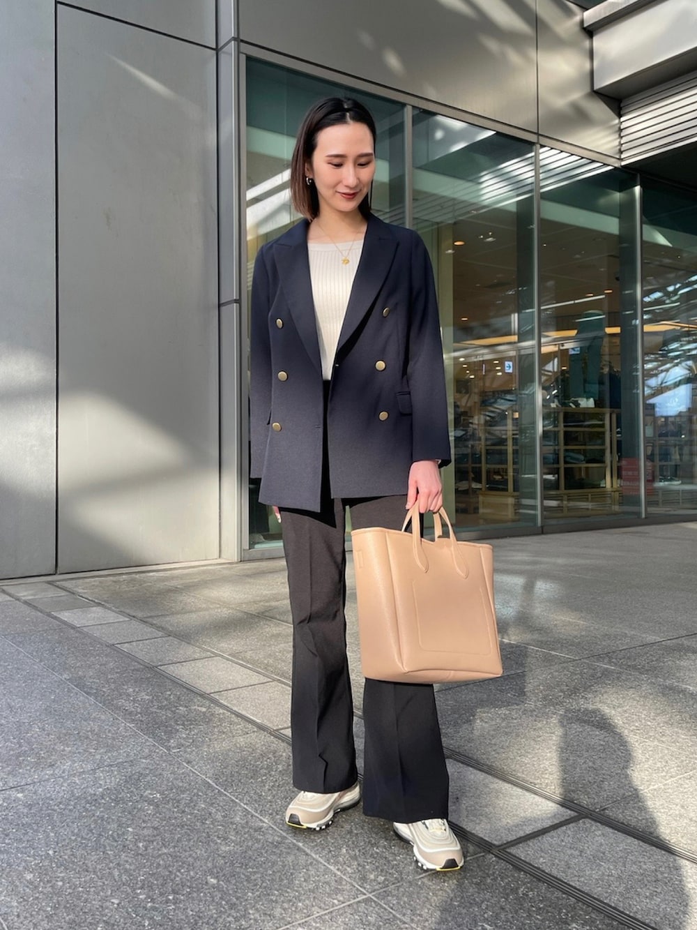 ブルー系のその他アウター、ベージュ系のニット/セーター、ベージュ系のトートバッグを着用したレディースの冬コーディネートの2枚目の写真