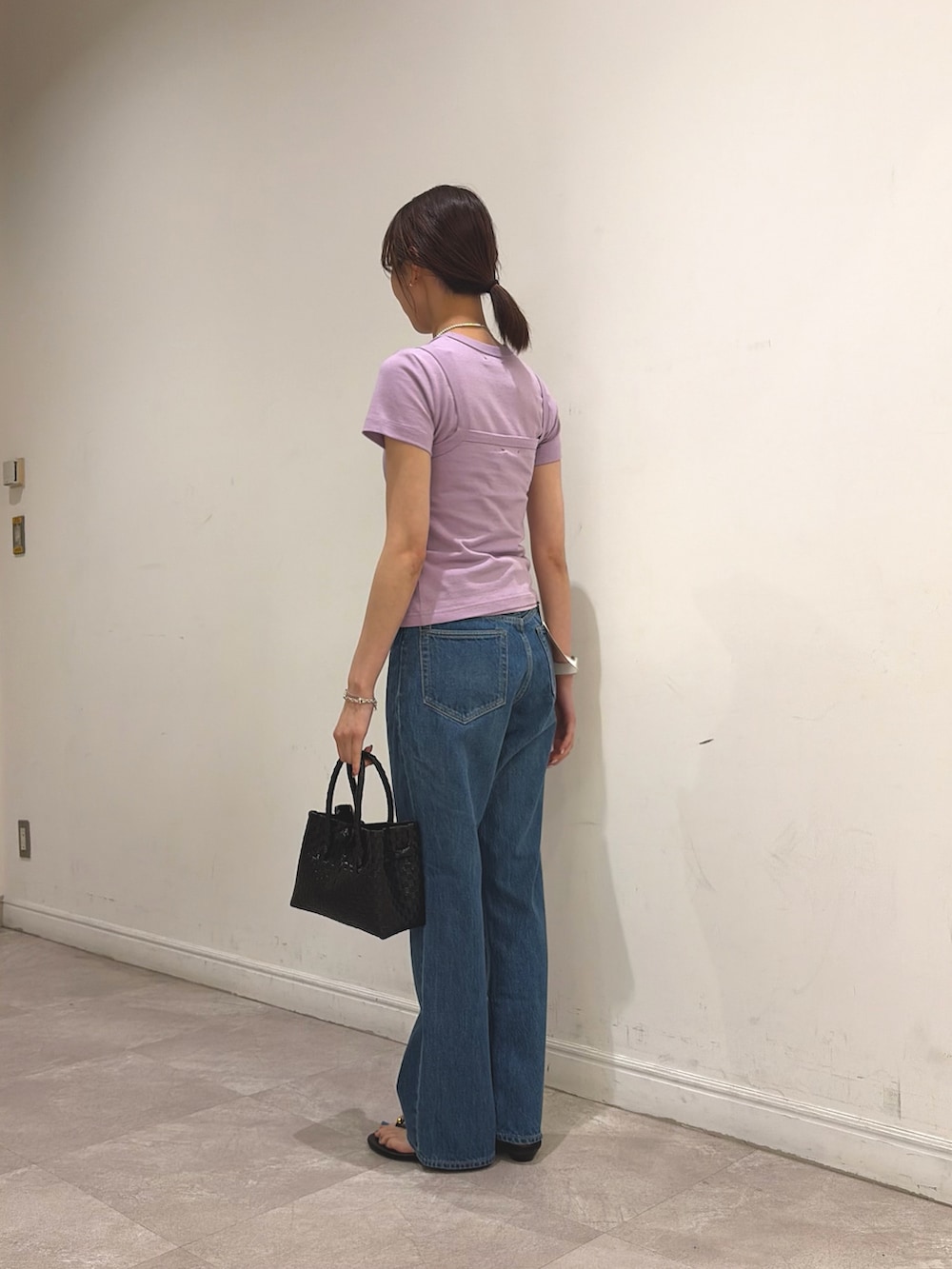 パープル系のTシャツ/カットソー、パープル系のキャミソール、ブルー系のデニムパンツを着用したレディースの夏コーディネートの3枚目の写真
