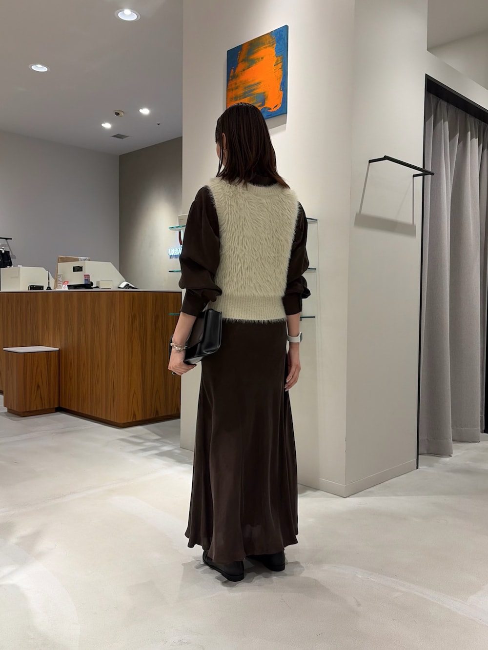 ブラウン系のシャツ/ブラウス、ブラウン系のスカート、ブラック系のハンドバッグを着用したレディースの秋コーディネートの4枚目の写真