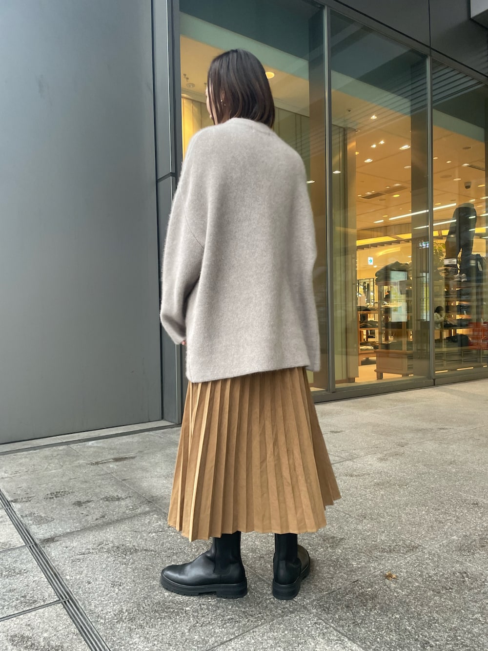 ベージュ系のカーディガン/ボレロ、ホワイト系のニット/セーター、イエロー系のスカートを着用したレディースの冬コーディネートの3枚目の写真