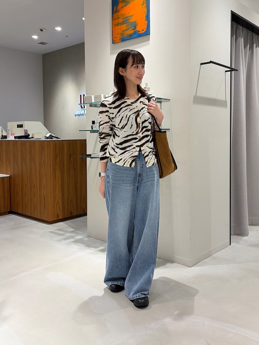 その他のカーディガン/ボレロ、ブルー系のデニムパンツ、ブラウン系のトートバッグを着用したレディースの秋コーディネートの2枚目の写真
