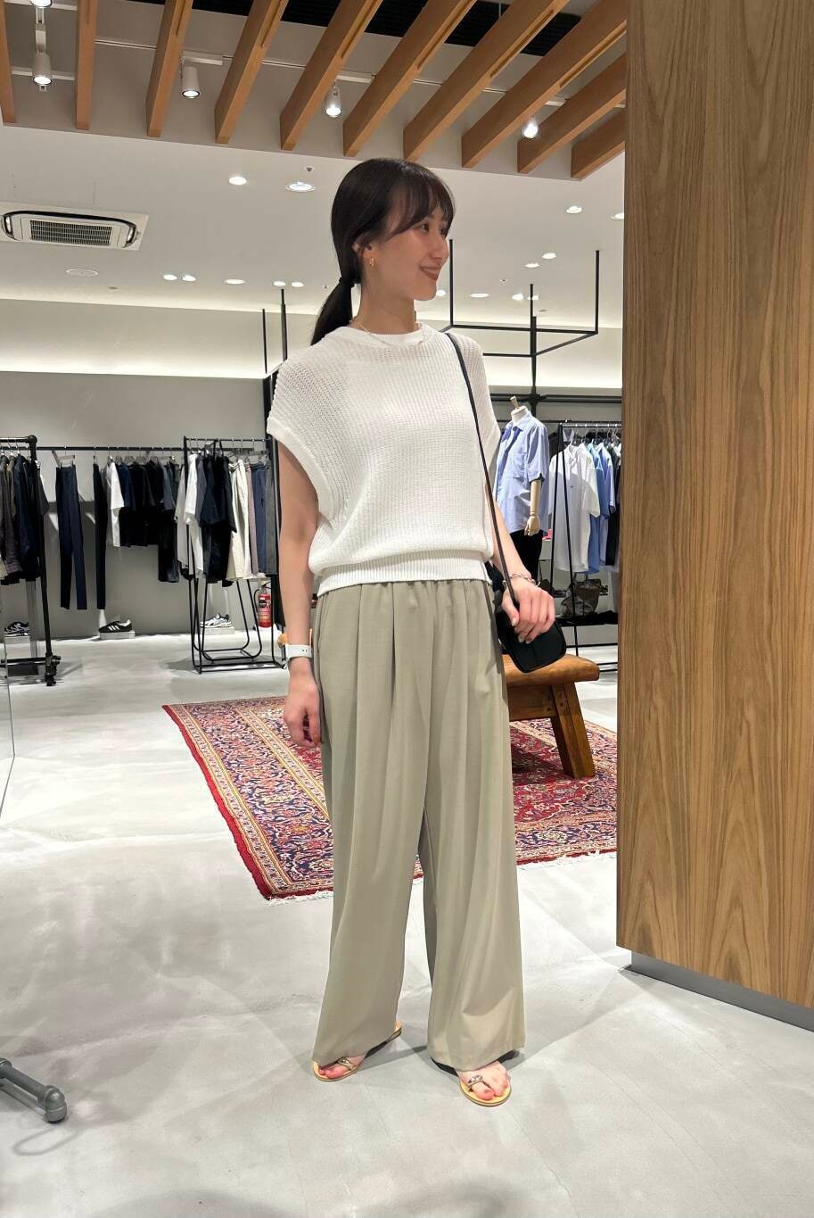 ベージュ系のその他パンツ、ブラック系のショルダーバッグ、ホワイト系のベストを着用したレディースの夏コーディネートの2枚目の写真