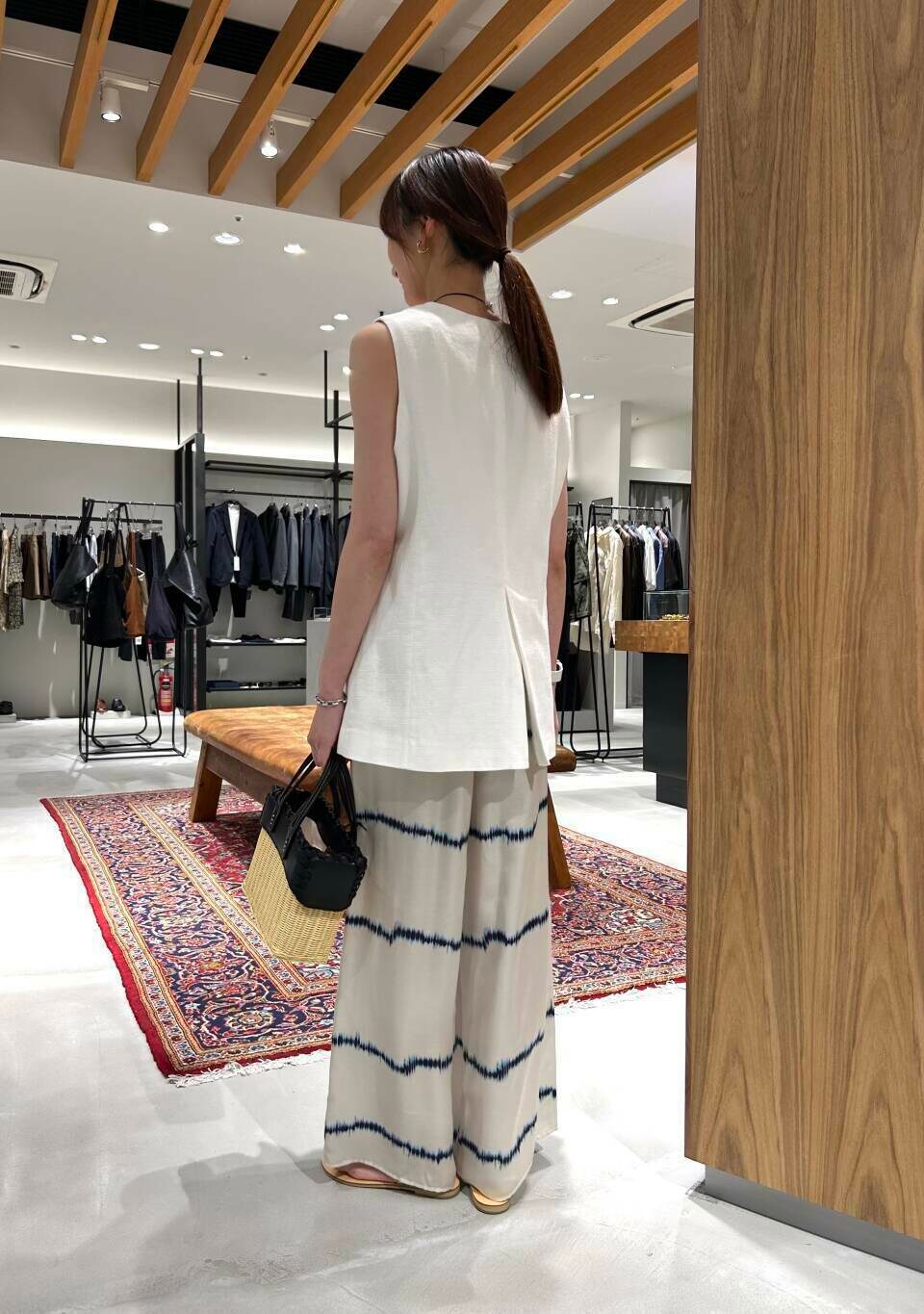 ホワイト系のタンクトップ、ゴールド系のサンダル、ホワイト系のその他パンツを着用したレディースの夏コーディネートの3枚目の写真