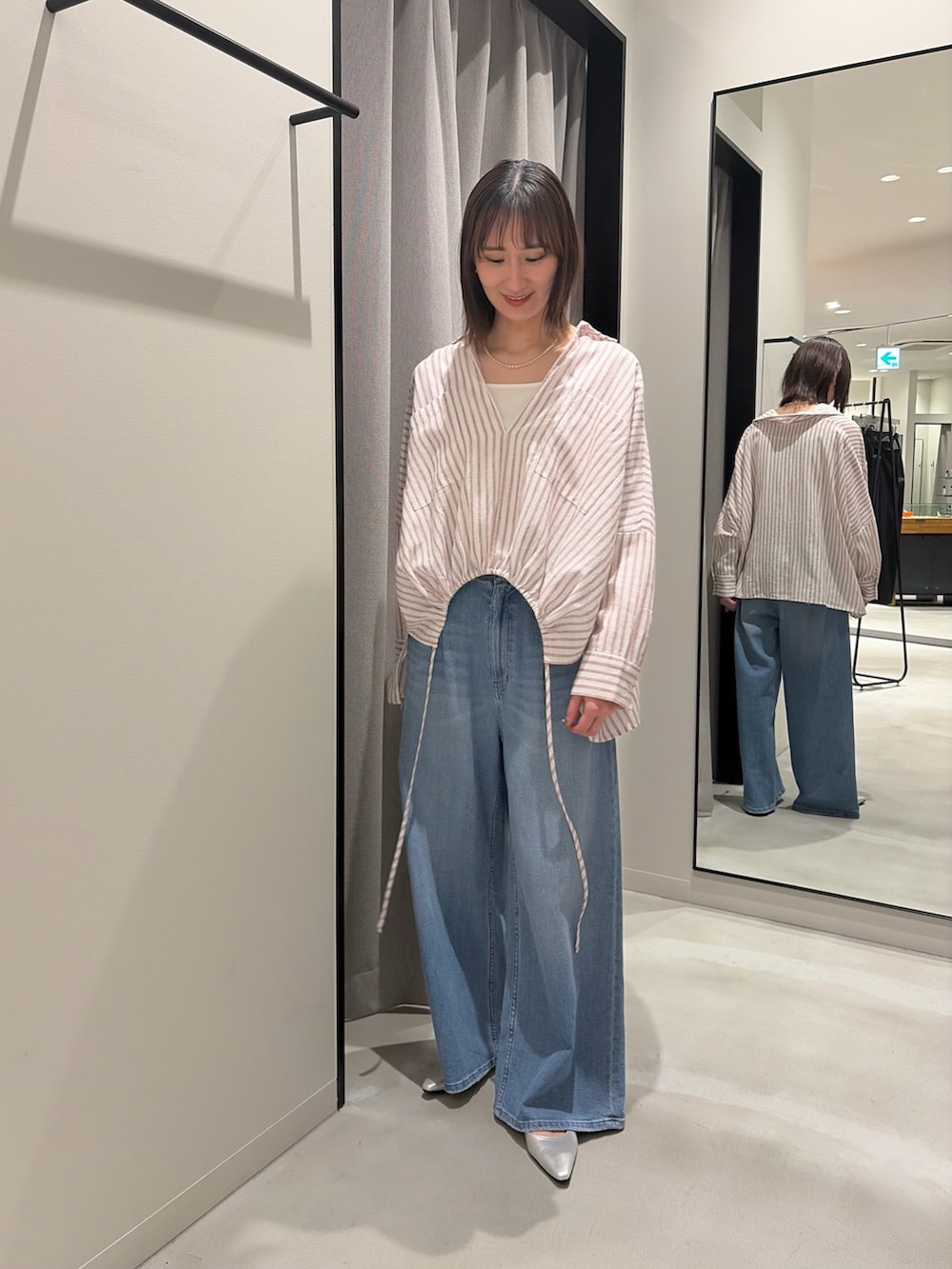 レッド系のシャツ/ブラウス、ホワイト系のタンクトップ、ブルー系のデニムパンツを着用したレディースの春コーディネートの2枚目の写真