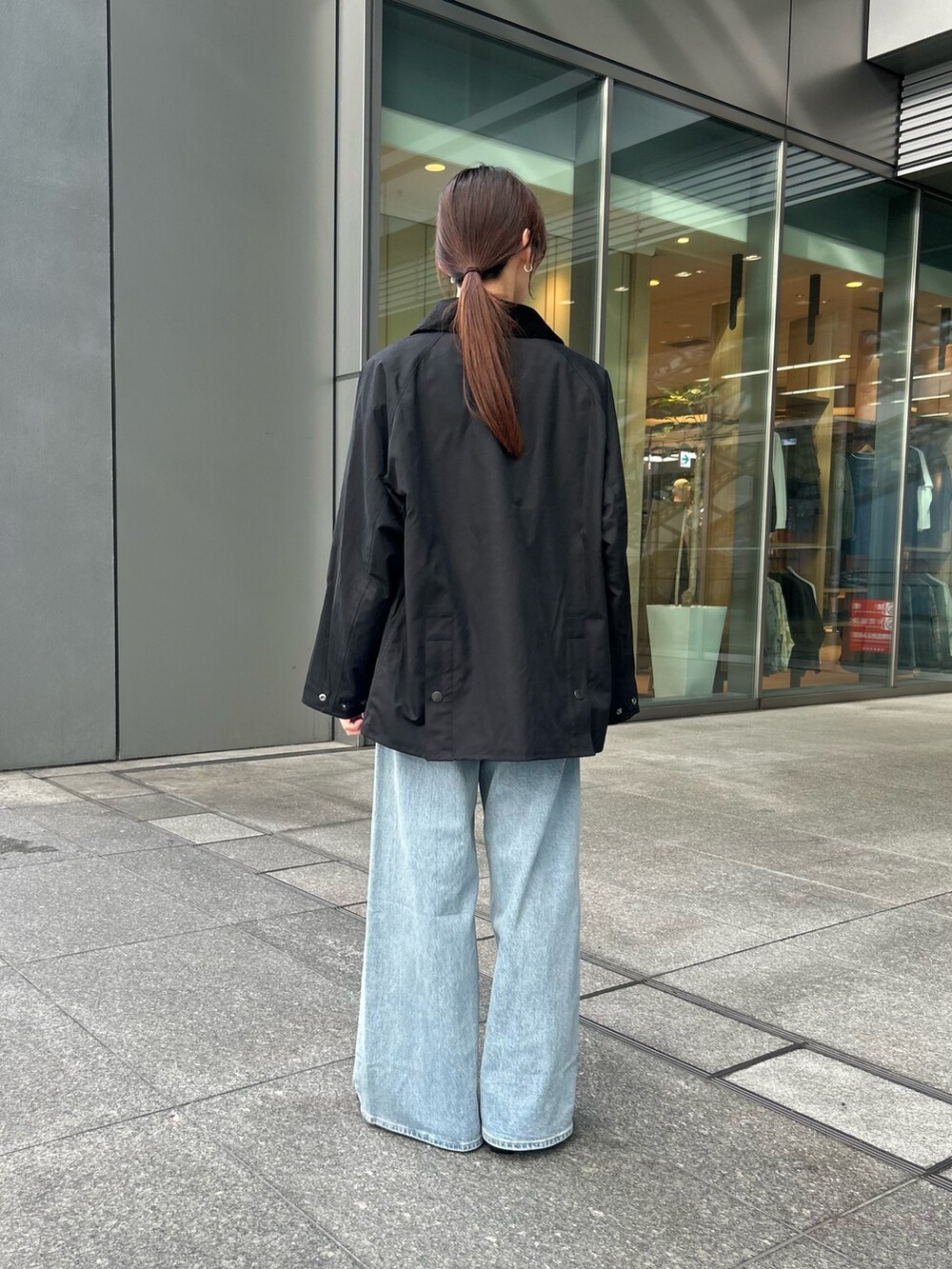 グリーン系のニット/セーター、ブルー系のデニムパンツ、ブラック系のローファーを着用したレディースの秋コーディネートの3枚目の写真