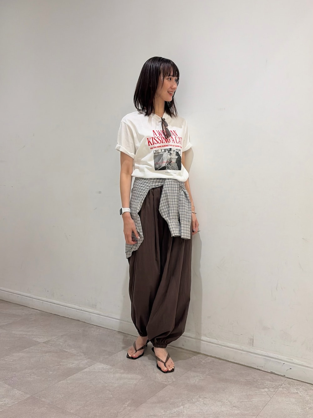 ブラウン系のその他パンツ、ブラック系のサンダル、ベージュ系のシャツ/ブラウスを着用したレディースの夏コーディネートの2枚目の写真
