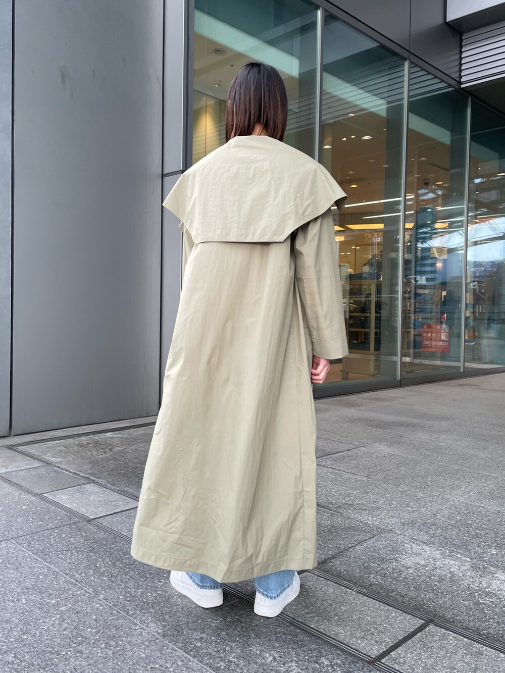 グリーン系のTシャツ/カットソー、ブルー系のデニムパンツ、ブラック系のトートバッグを着用したレディースの冬コーディネートの3枚目の写真