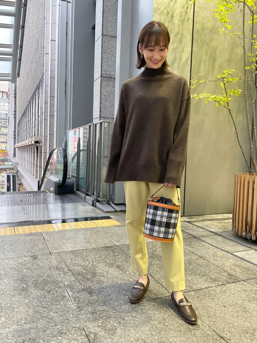 ベージュ系のその他アウター、その他のバッグ、ブラウン系のニット/セーターを着用したレディースの冬コーディネートの3枚目の写真