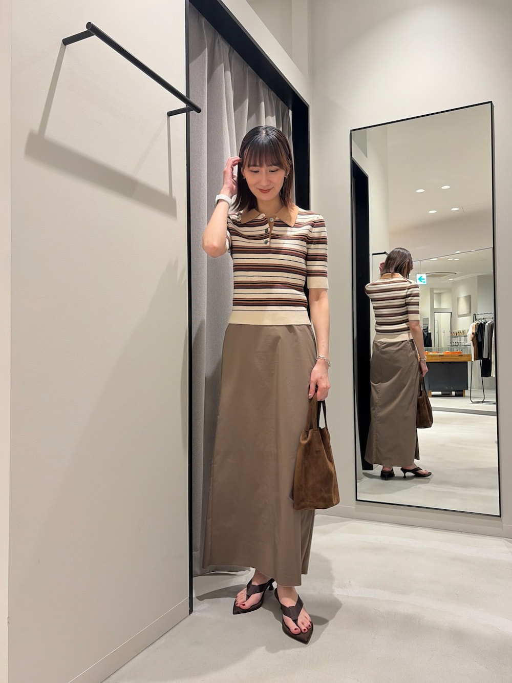 ホワイト系のニット/セーター、グレー系のスカート、ブラウン系のサンダルを着用したレディースの夏コーディネートの2枚目の写真