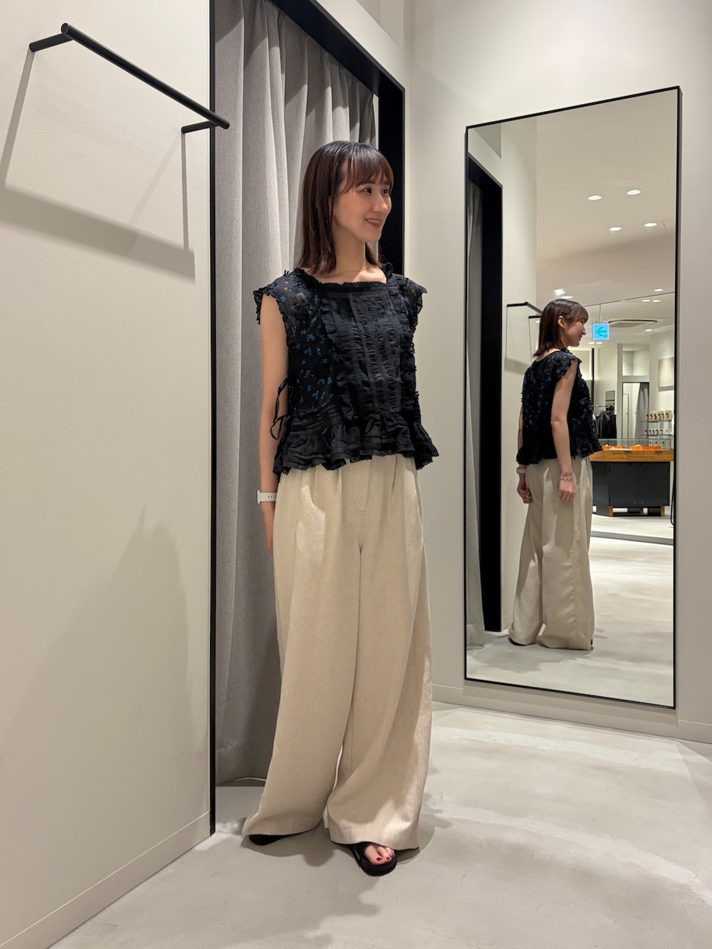ブラック系のシャツ/ブラウス、ホワイト系のその他パンツ、ブラック系のサンダルを着用したレディースの春コーディネートの2枚目の写真