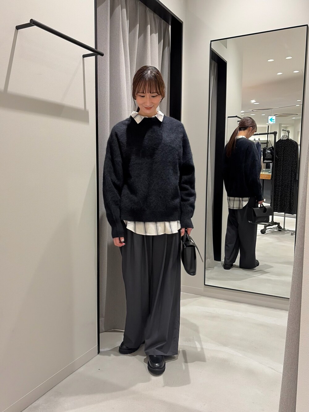 ホワイト系のシャツ/ブラウス、グレー系のその他パンツ、ブラック系のハンドバッグを着用したレディースの冬コーディネートの2枚目の写真