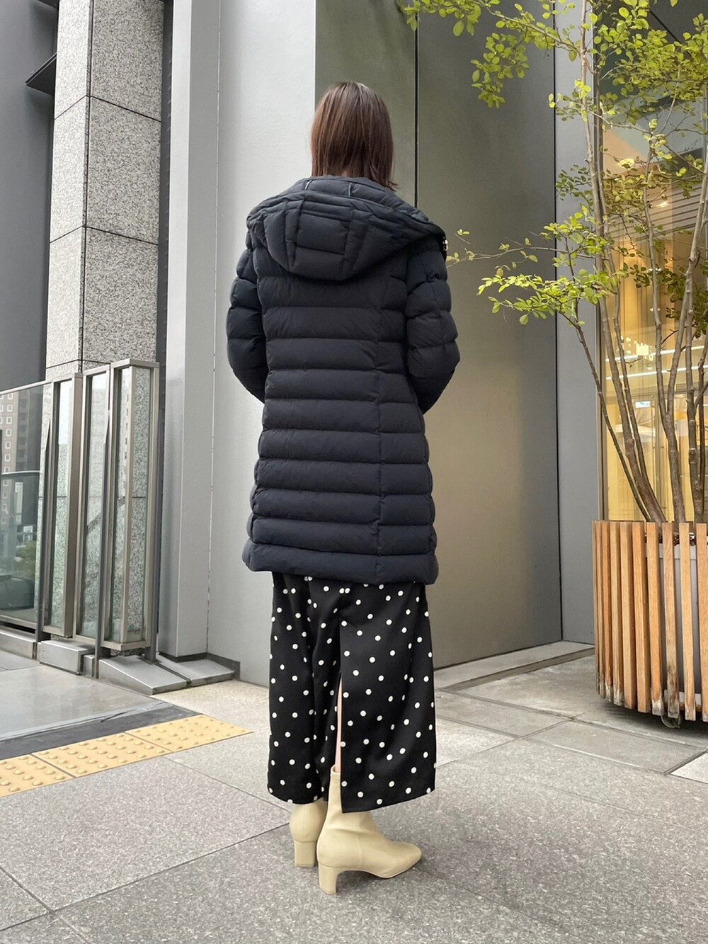 ブラック系のダウンジャケット/コート、レッド系のニット/セーター、ブラック系のスカートを着用したレディースの冬コーディネートの3枚目の写真