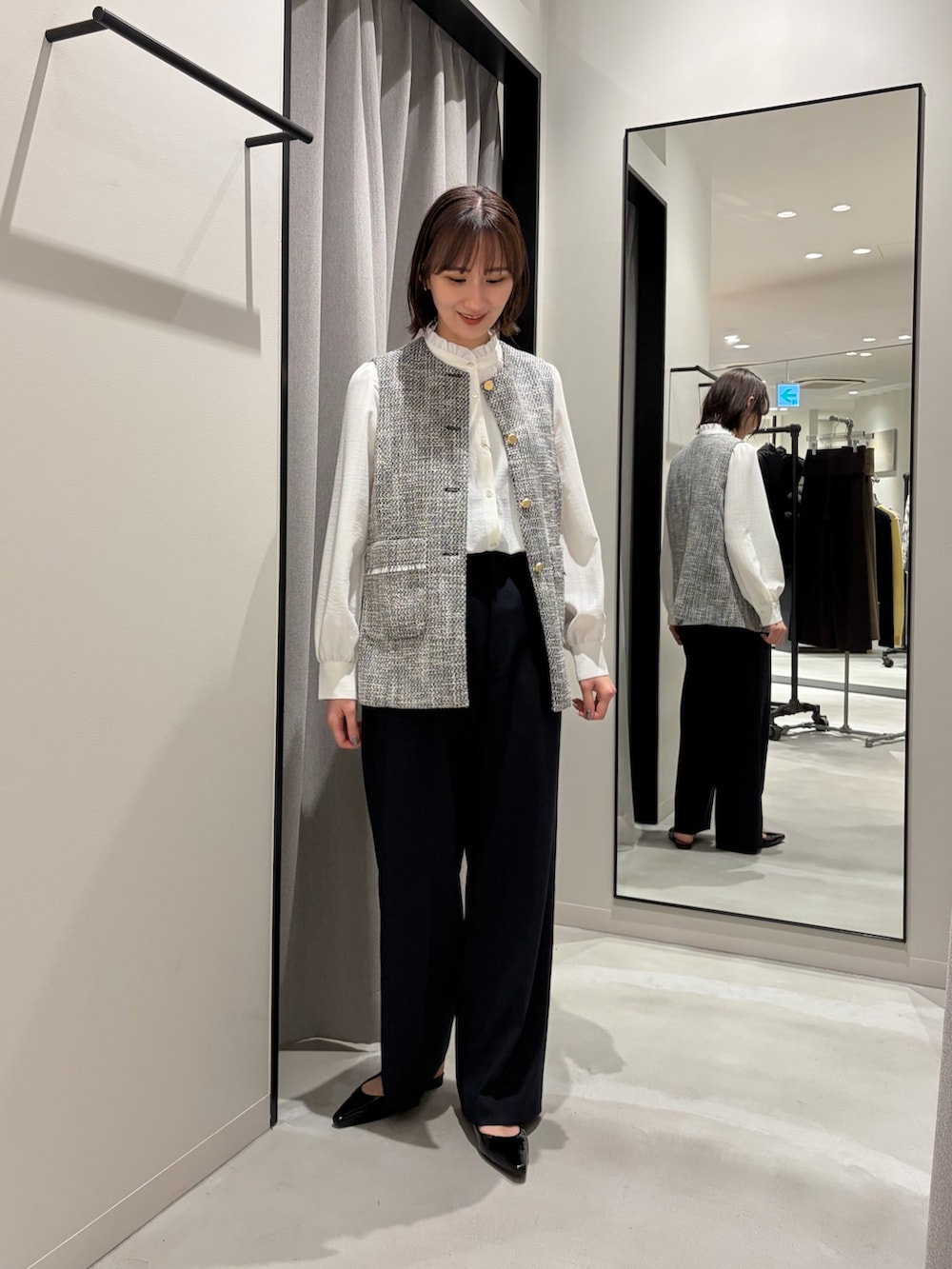 ブラック系のその他アウター、ホワイト系のシャツ/ブラウス、ブラック系のその他パンツを着用したレディースの冬コーディネートの4枚目の写真