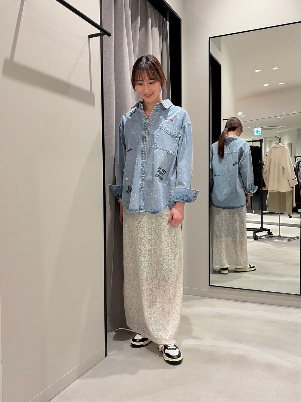 ブルー系のシャツ/ブラウス、ホワイト系のスカート、ブラック系のスニーカーを着用したレディースの冬コーディネートの2枚目の写真