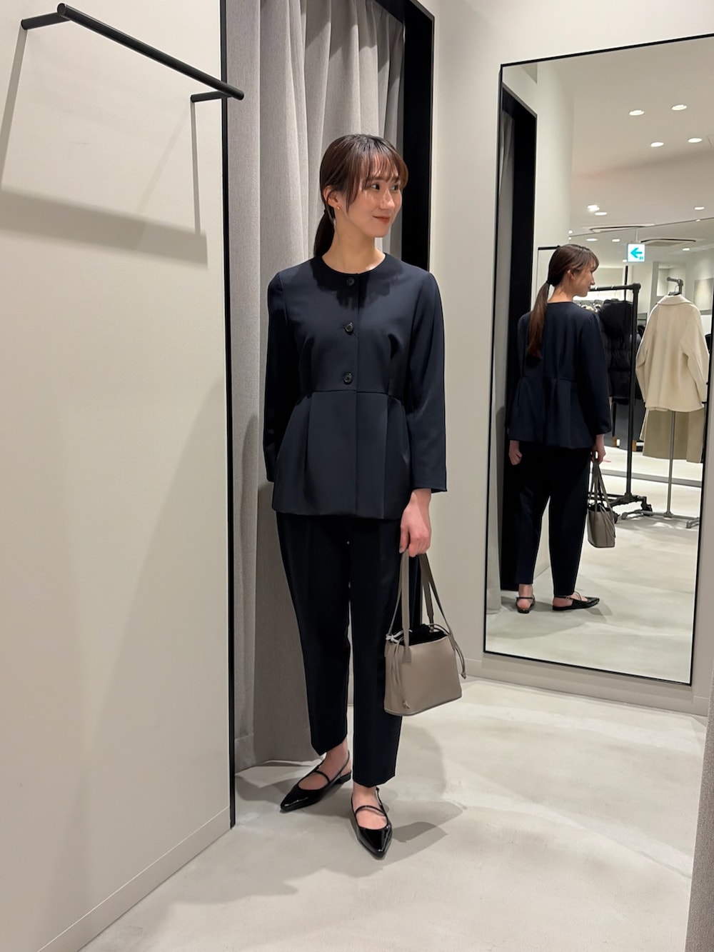 ブラック系のパンプス、ブルー系のノーカラージャケット、ブルー系のその他パンツを着用したレディースの冬コーディネートの2枚目の写真