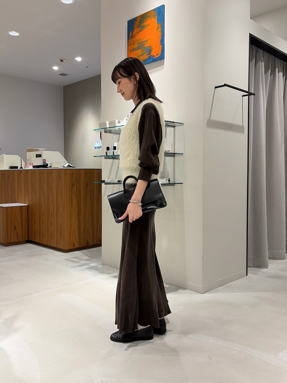 ブラウン系のシャツ/ブラウス、ブラウン系のスカート、ブラック系のハンドバッグを着用したレディースの秋コーディネートの3枚目の写真