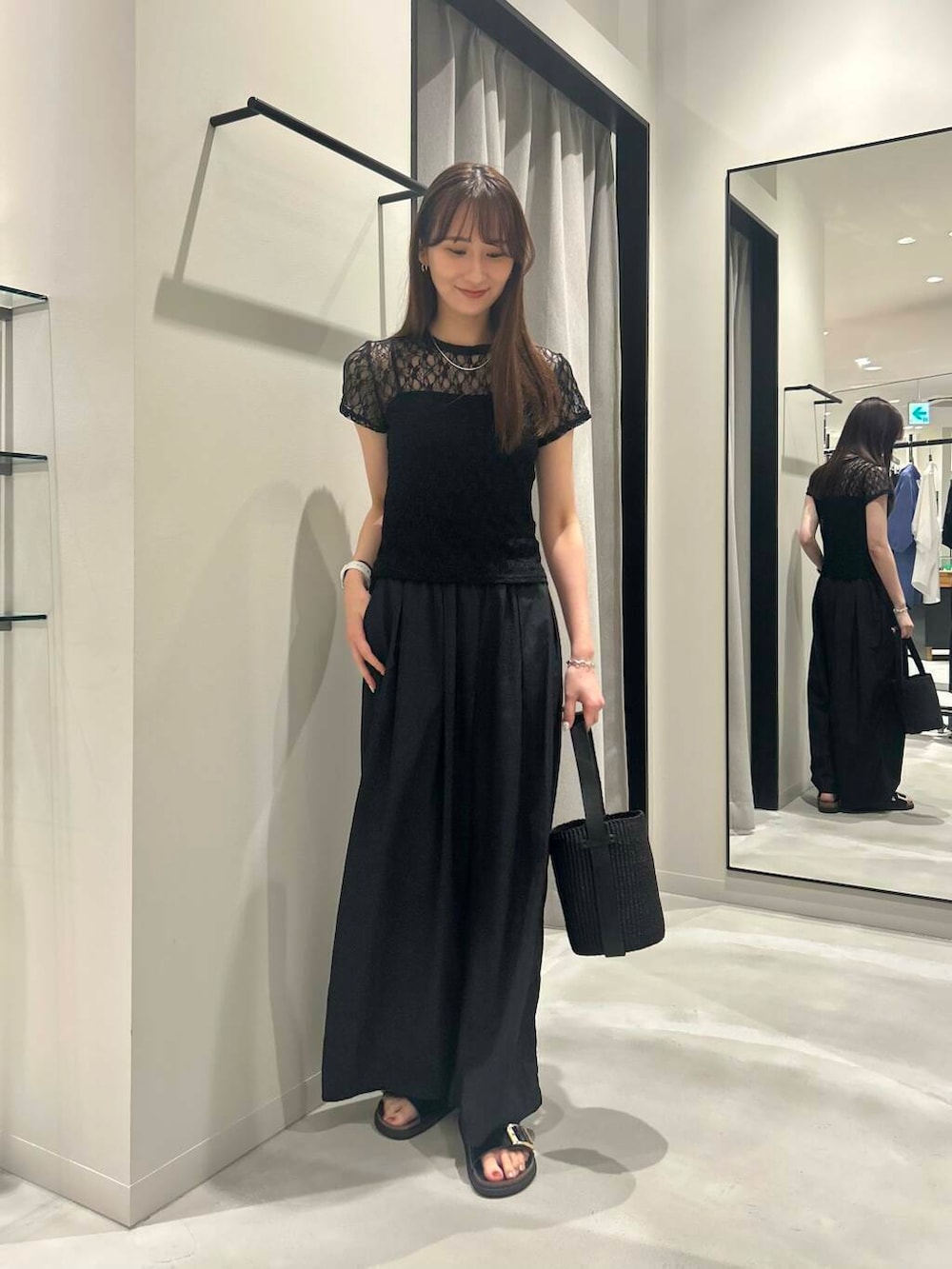 ブラック系のその他パンツ、ブラック系のかごバッグ、ブラック系のサンダルを着用したレディースの夏コーディネートの2枚目の写真