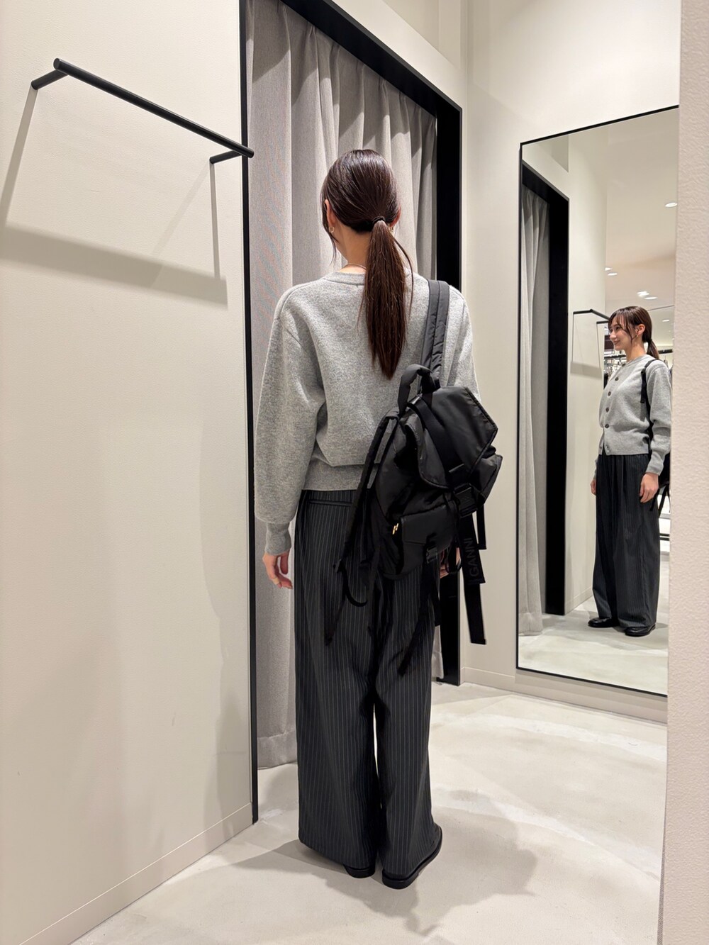 グレー系のカーディガン/ボレロ、その他のその他パンツ、ブラック系のバックパック/リュックを着用したレディースの秋コーディネートの4枚目の写真