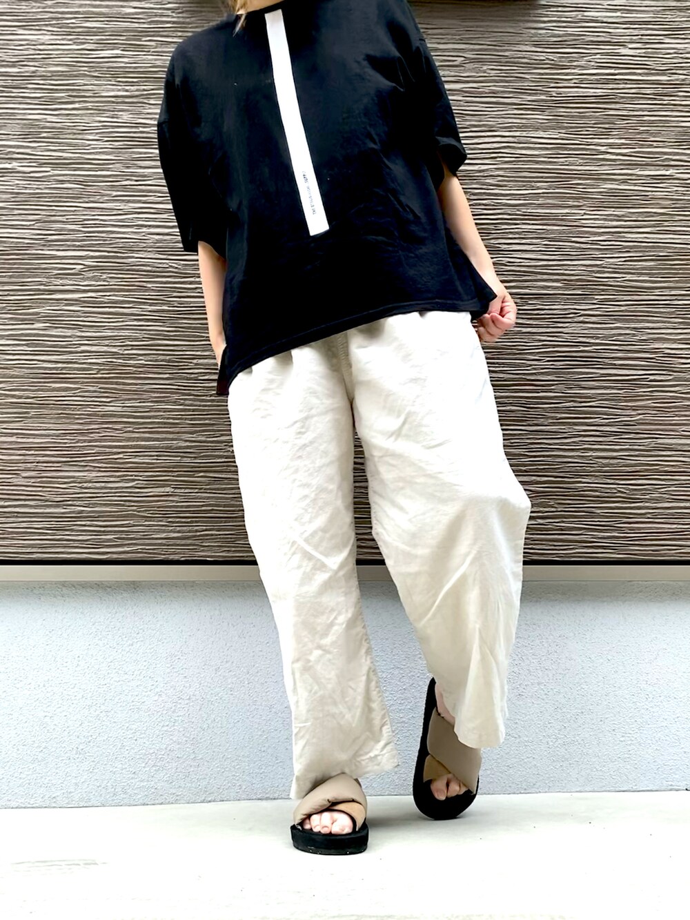 ブラック系のTシャツ/カットソー、ベージュ系のパンツ、ベージュ系のサンダルを着用したレディースの夏コーディネートの3枚目の写真