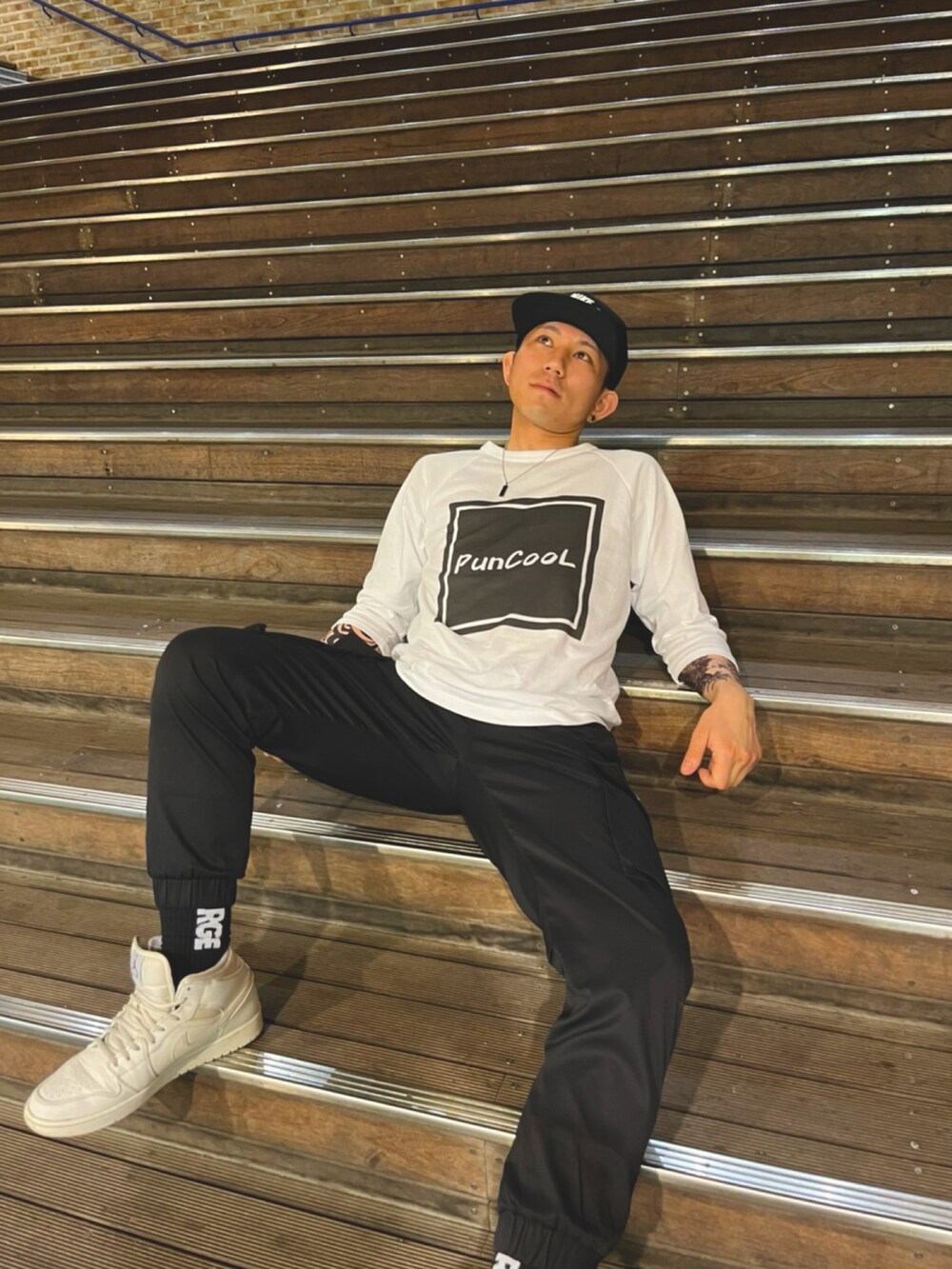 ホワイト系のスニーカー、ホワイト系のTシャツ/カットソー、ブラック系のカーゴパンツを着用したメンズの春コーディネートの3枚目の写真