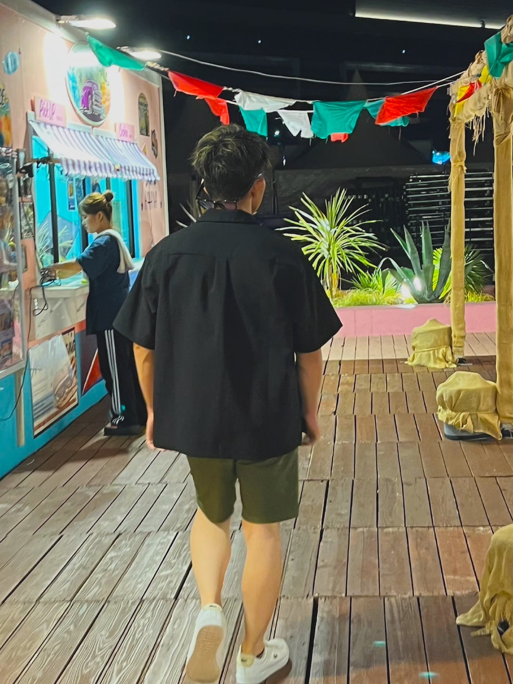 ホワイト系のスニーカー、ブラック系のシャツ/ブラウス、グリーン系のチノパンツを着用したメンズの夏コーディネートの3枚目の写真