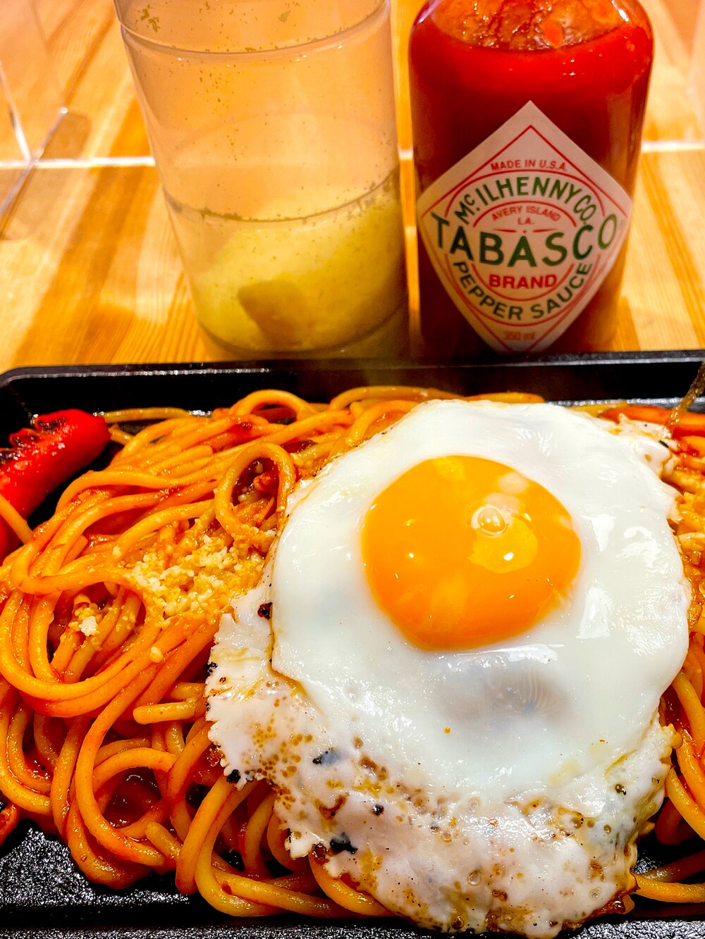 グリーン系のワンピース、ブラック系のライダースジャケット、ブラック系のパンプスを着用したレディースの秋コーディネートの2枚目の写真