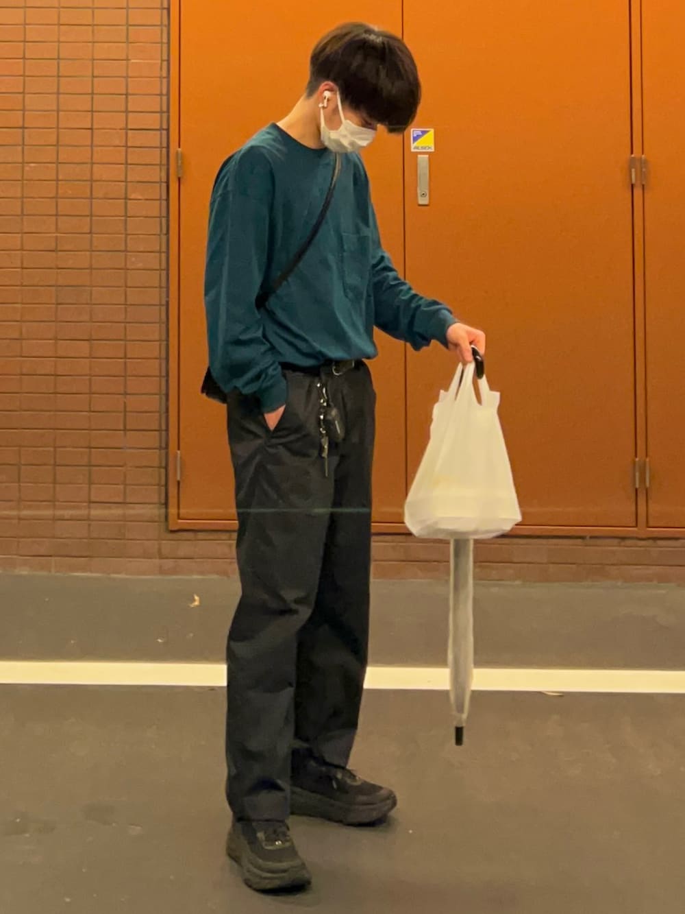 ブラック系のパンツ、ブラック系のスニーカー、グリーン系のTシャツ/カットソーを着用したメンズの秋コーディネートの2枚目の写真