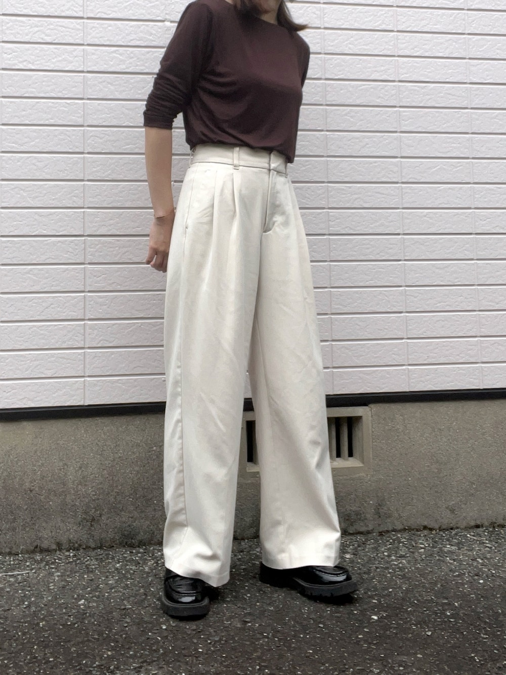 ブラウン系のTシャツ/カットソー、ホワイト系のスラックス、ブラック系のローファーを着用したレディースの夏コーディネートの2枚目の写真