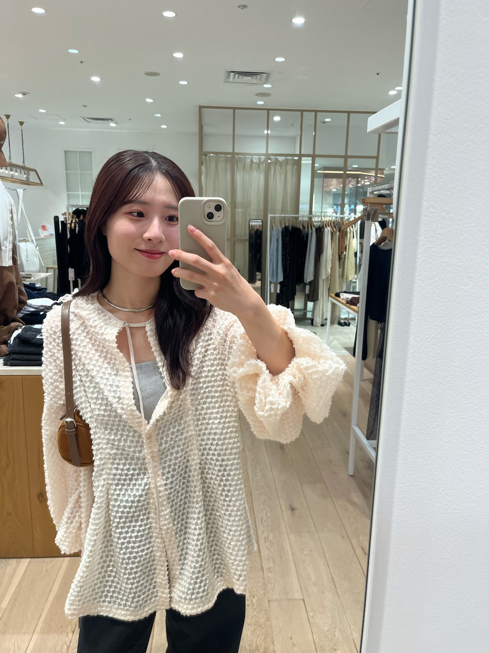 ブラック系のデニムパンツ、ピンク系のチュニック、グレー系のキャミソールを着用したレディースの秋コーディネートの4枚目の写真