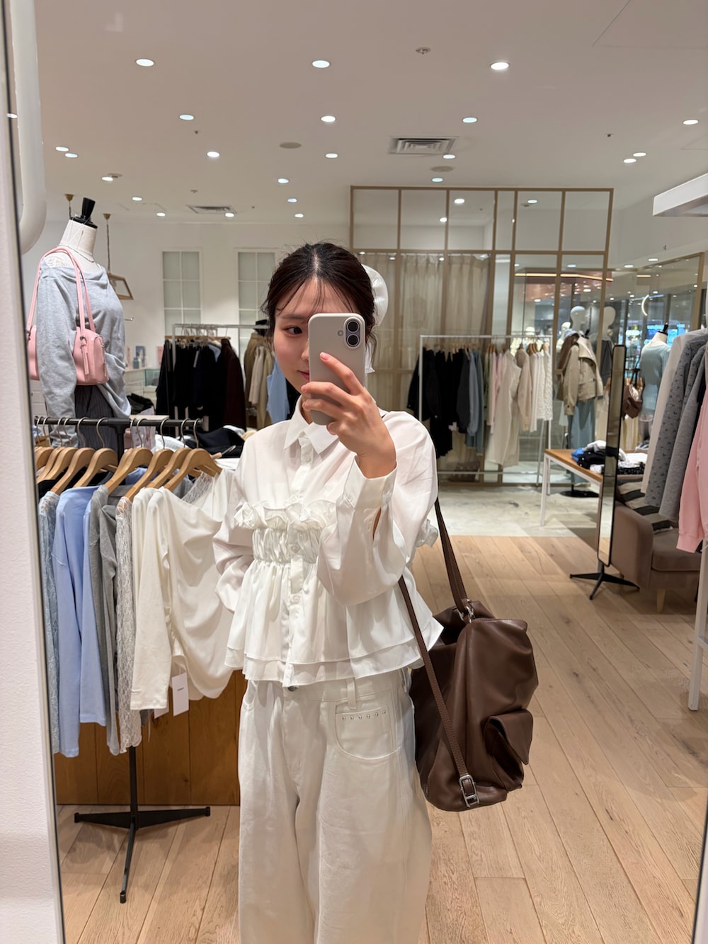 ホワイト系のデニムパンツ、ホワイト系のシャツ/ブラウス、イエロー系のトートバッグを着用したレディースの冬コーディネートの2枚目の写真