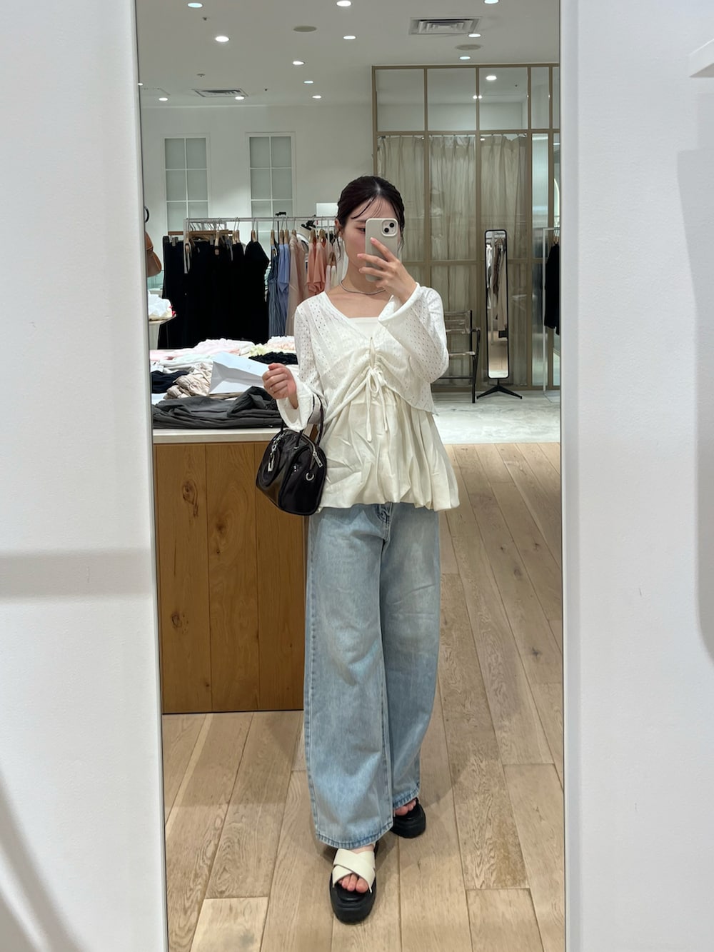 ホワイト系のシャツ/ブラウス、ホワイト系のカーディガン/ボレロ、ブルー系のデニムパンツを着用したレディースの夏コーディネートの2枚目の写真